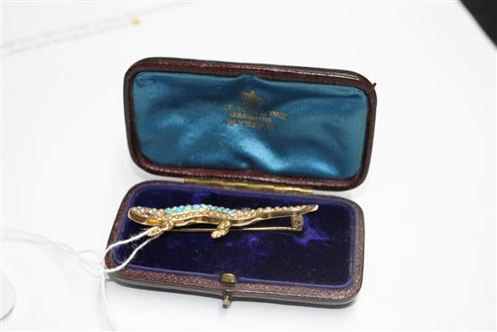 An Edwardian yellow metal(stamped 15), turquoise and seed pearl set lizard brooch, with gem set eyes, 55mm, gross 6.1 grams.